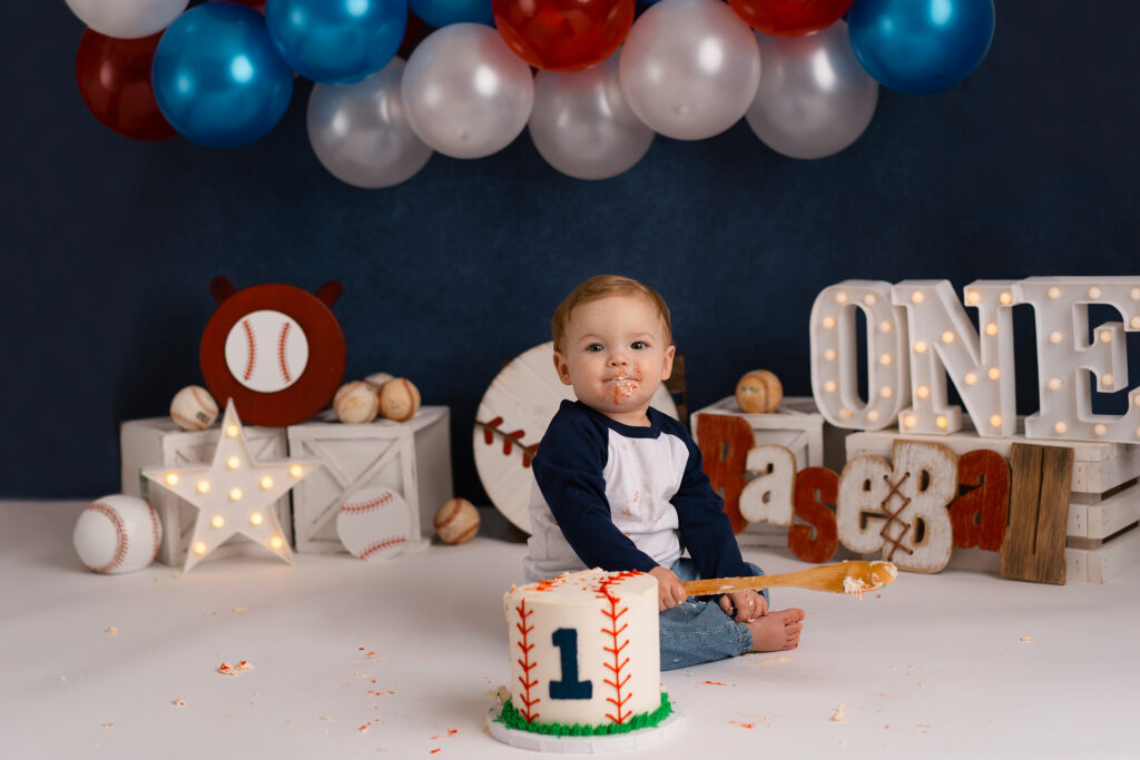 Charleston photographer captures baseball cake smash with baby boy enjoying cake"