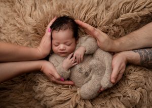 Mother gently holding her newborn during a timeless family portrait session in Charleston.