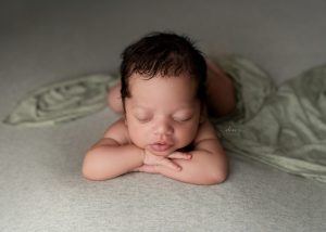 Luxury newborn portrait by a Charleston newborn photographer featuring a sleeping baby wrapped in soft neutral fabrics.
